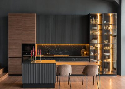 A modern kitchen with black walls and wooden cabinets.